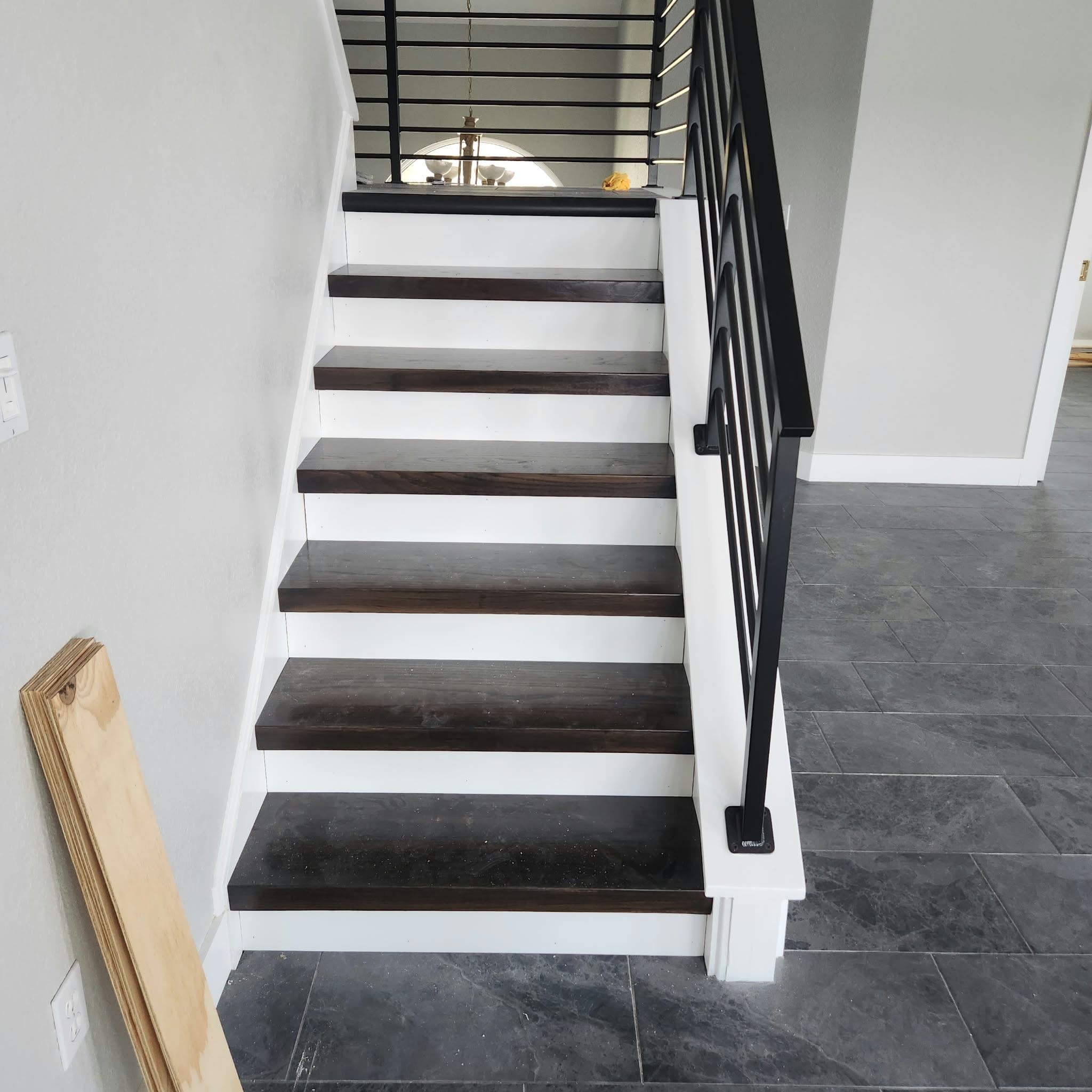 Modern staircase with dark wood treads, white risers and black metal railing